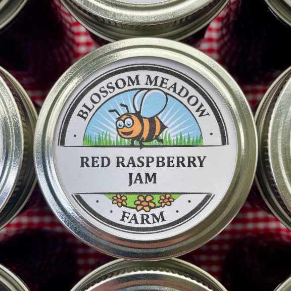 Blossom Meadow Red Raspberry Jam jar lid on a red and white checkered tablecloth