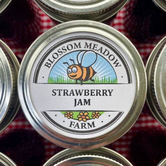 Jar of Blossom Meadow Strawberry Jam with a bee illustration on a red and white checkered background.